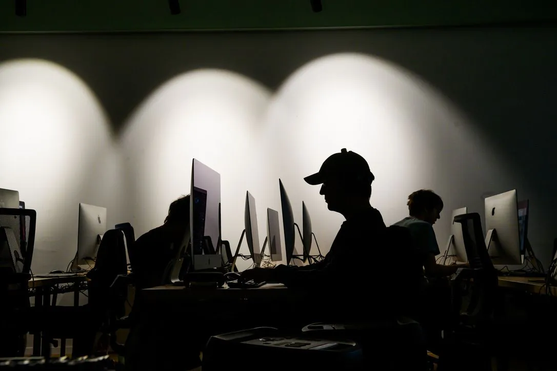 Two students working at a cluster of computers in Renens.