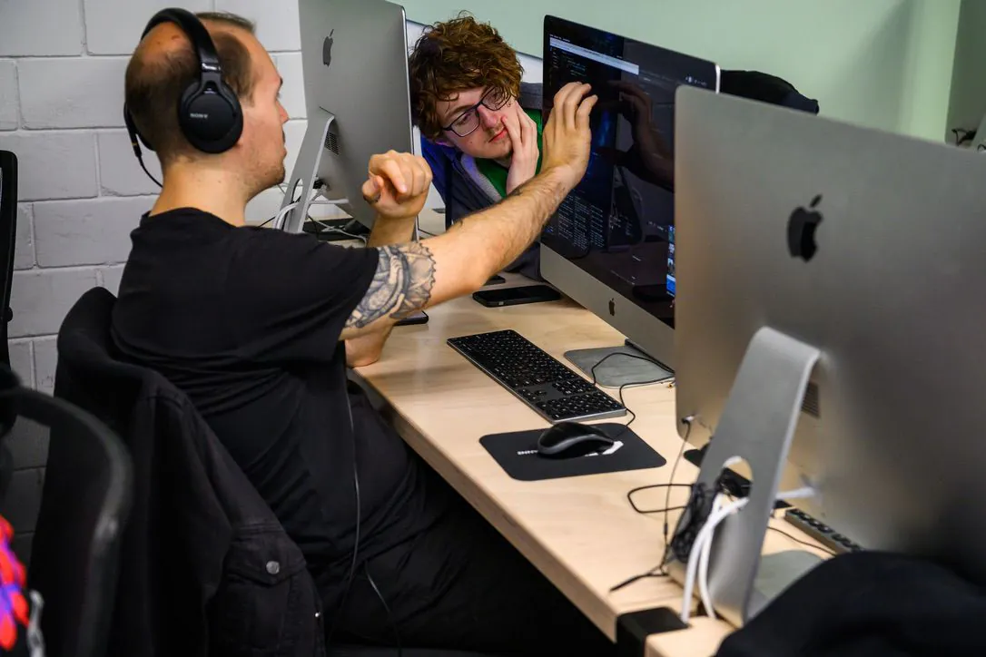 A student showing something on their screen to another student.
